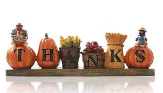 Thanksgiving decoration with pumpkins and baskets spelling “THANKS”