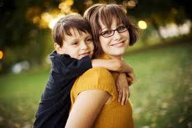 Young mother carrying her son on her back