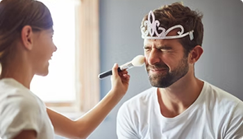 Young girl applying makeup to her father dressed as a princess